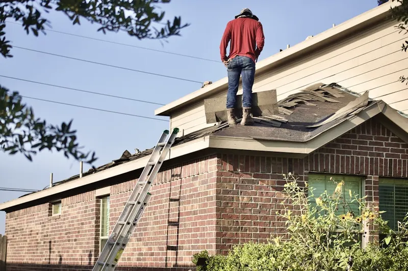 Professional roofer working on a residential roof in Schuyler Falls